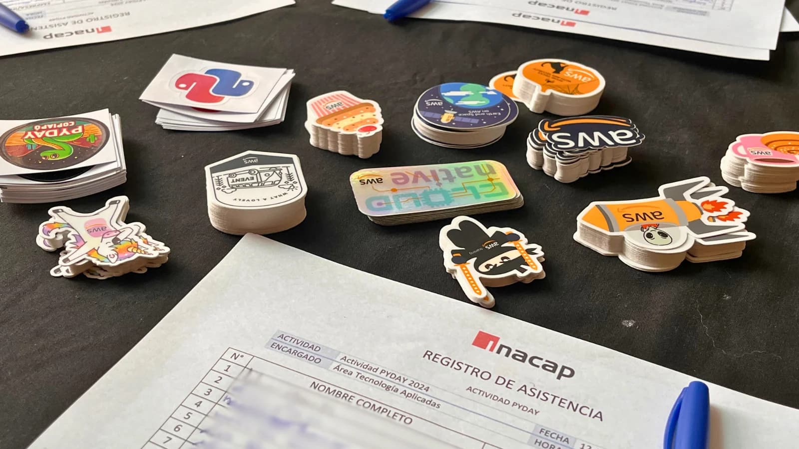 Mesa de registro con stickers de Python y PyDay